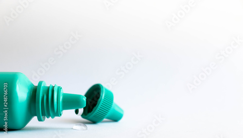 Green plastic eye dropper bottle isolated on white background.