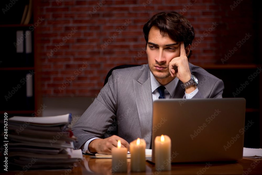 Businessman working late in office with candle light Businessman working late in office with candle light