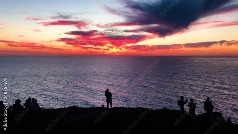 Sunset over Atlantic ocean Tourist people girl woman silhouette. View from Cabo da Roca (Cape Roca), a cape which forms the westernmost extent of mainland Portugal and continental Europe Sunset over Atlantic ocean Tourist people girl woman silhouette. View from Cabo da Roca (Cape Roca), a cape which forms the westernmost extent of mainland Portugal and continental Europe