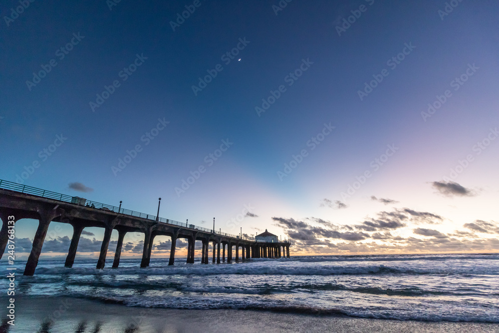 Sunset behind the pier at Manhattan Beach, California