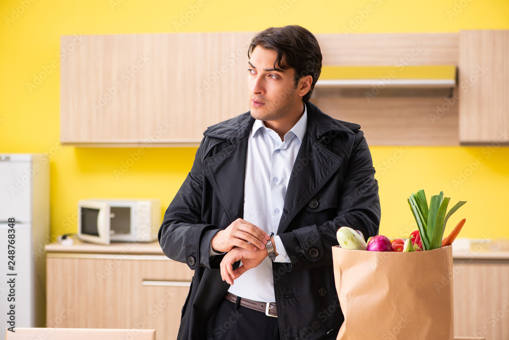 Young handsome man with vegetables in kitchen Young handsome man with vegetables in kitchen