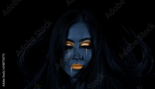 High fashion model woman. Art blue, gold skin girl face portrait