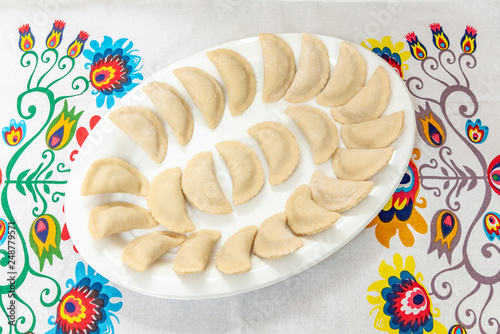 Pierogi laid out on a plate ready for boiling