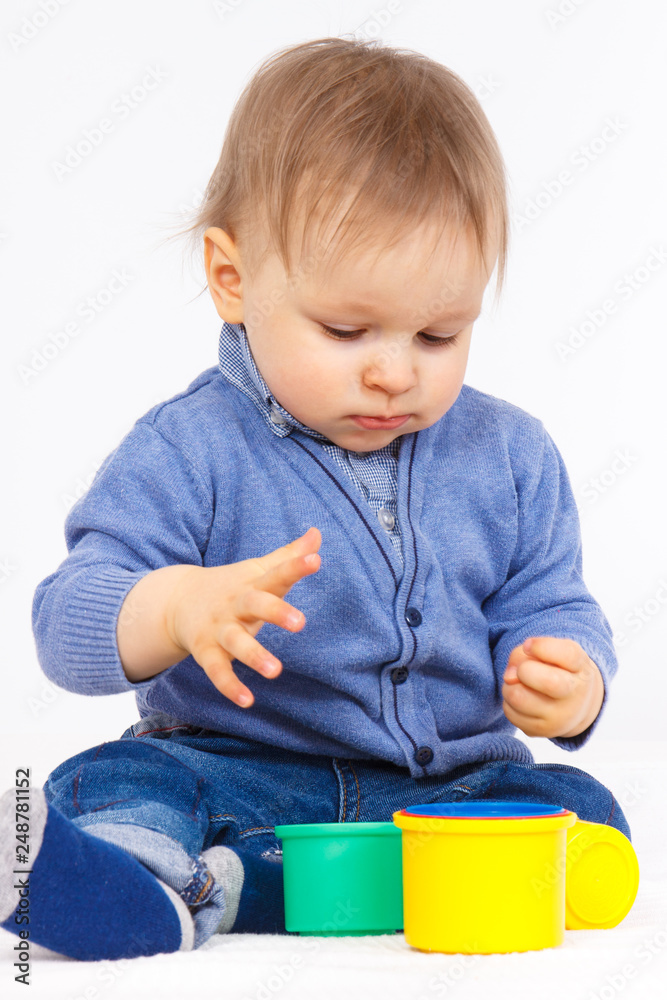 Little baby boy playing with plastic colorful cups, child development concept Little baby boy playing with plastic colorful cups, child development concept
