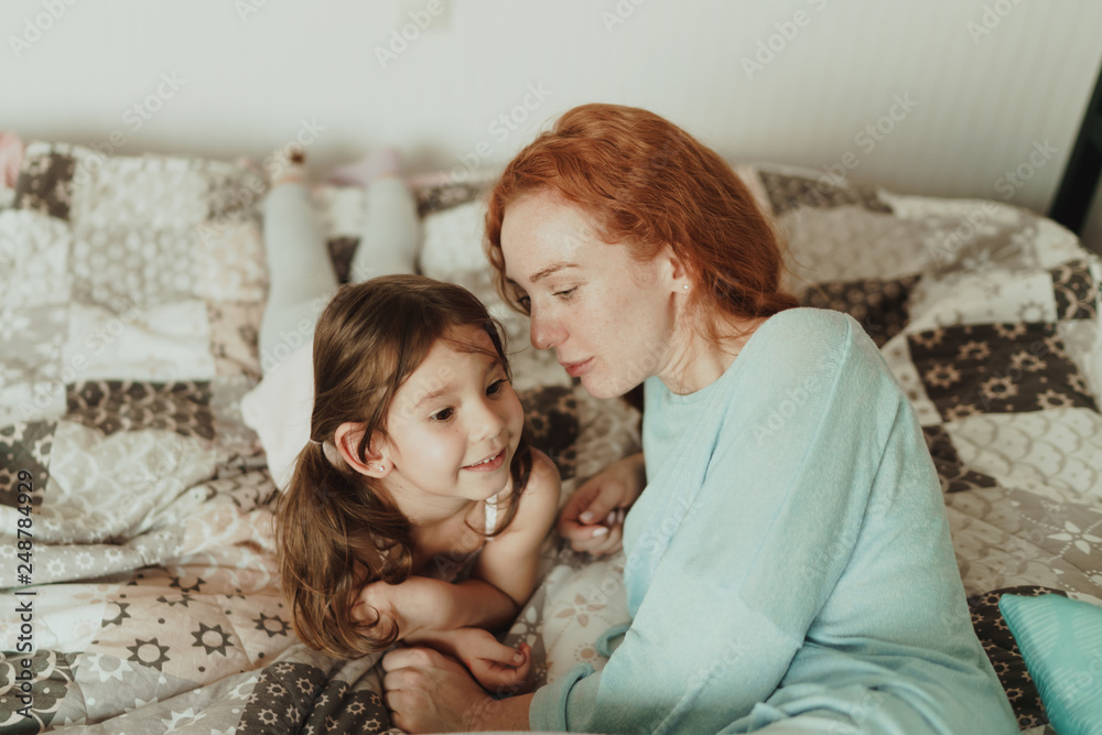 cozy photo session of beautiful happy mother and daughter,