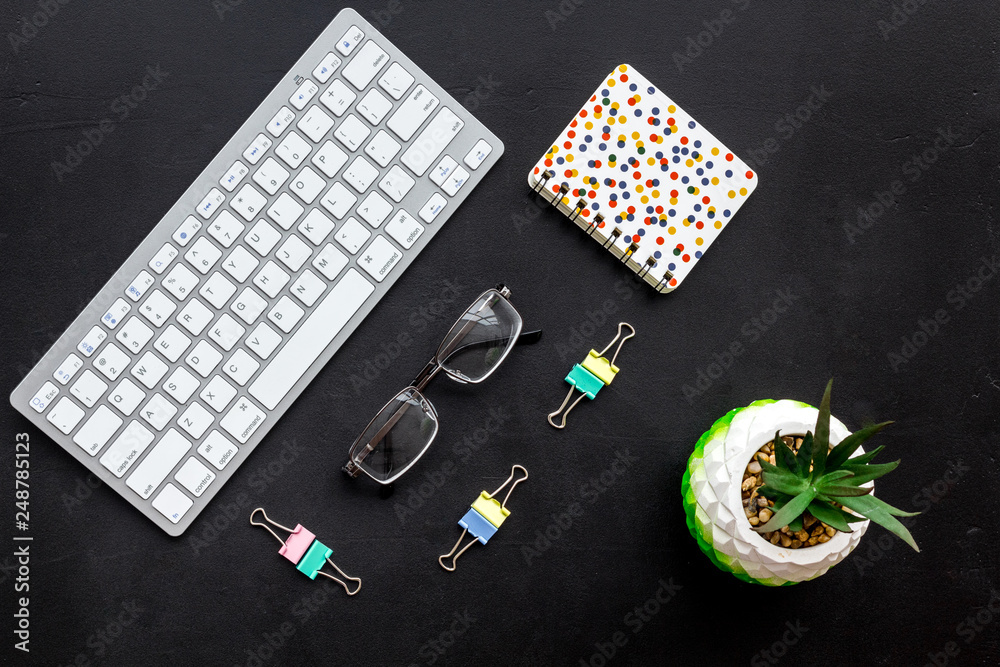 Obraz premium Work desk of manager. Computer keyboard, glasses, stationery, plant on black background top view space for text