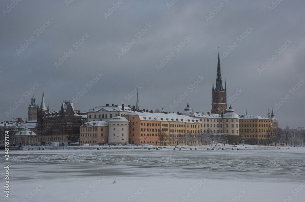 Fototapeta premium Winter view over the Riddarholmen island a gray and snowy winter day