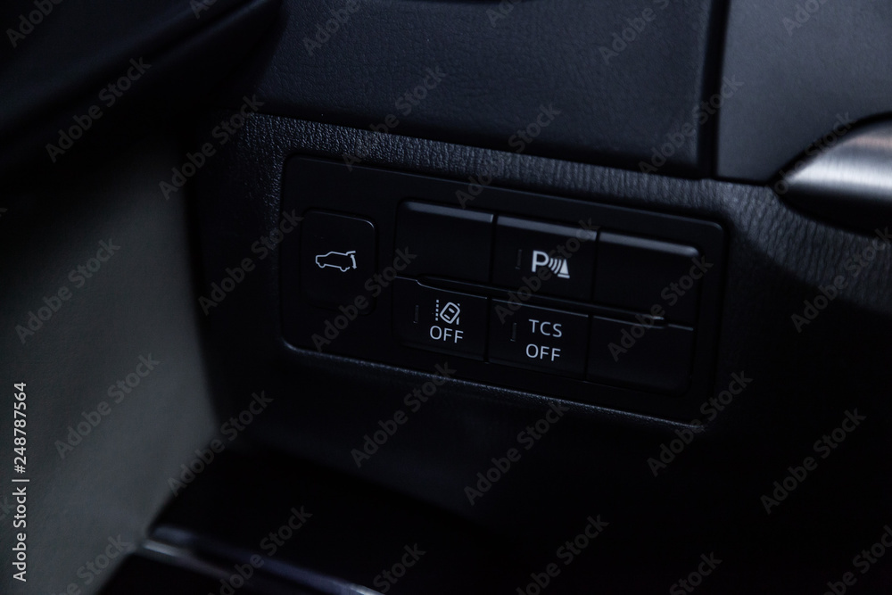 Сlose-up of the car black interior: trunk release buttons, parking systems and other buttons. Сlose-up of the car black interior: trunk release buttons, parking systems and other buttons.