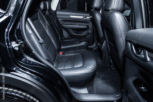 Сlose-up of the car  black interior:  black leather rear seats and seat belts . © Виталий Сова