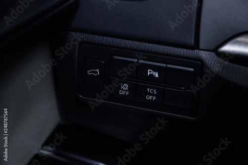 Сlose-up of the car black interior: trunk release buttons, parking systems and other buttons.