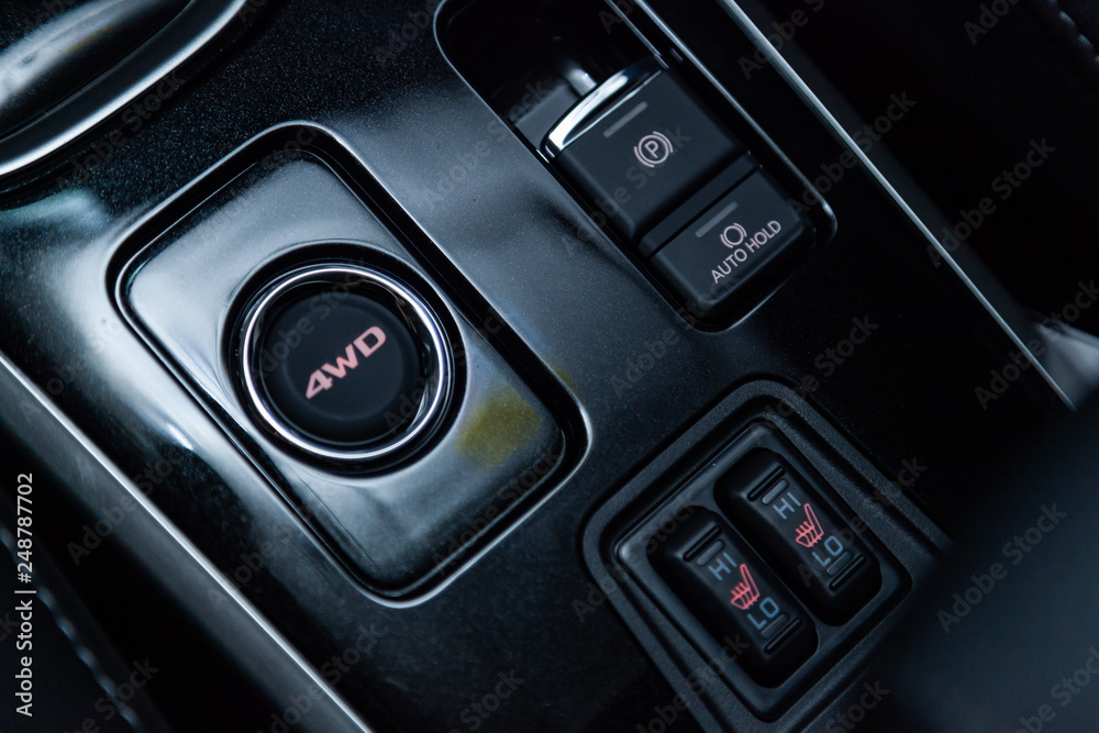 Сlose-up of the car  black interior:  seat heating buttons, parking systems, 4WD and other buttons.