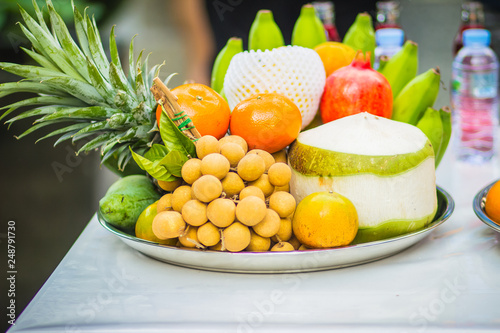 Set of fresh tropical fruits including banana  orange  pineapple  fresh water  red water  coconut  apple  mango  grape  longan  prepared for the spirits of the gods  worship ceremony