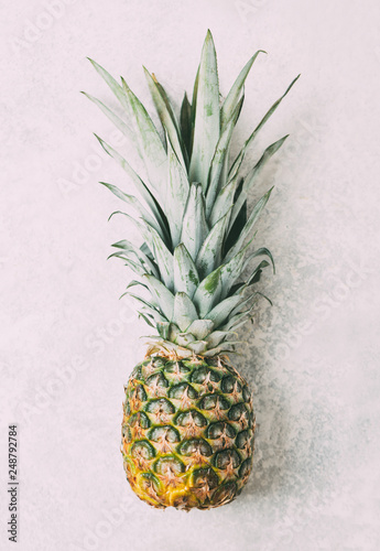 Ripe pineapple on grey textured background