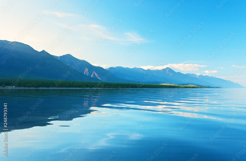 View from the water on the shore of Lake Baikal on a quiet summer evening. Beautiful summer landscape. Sea background