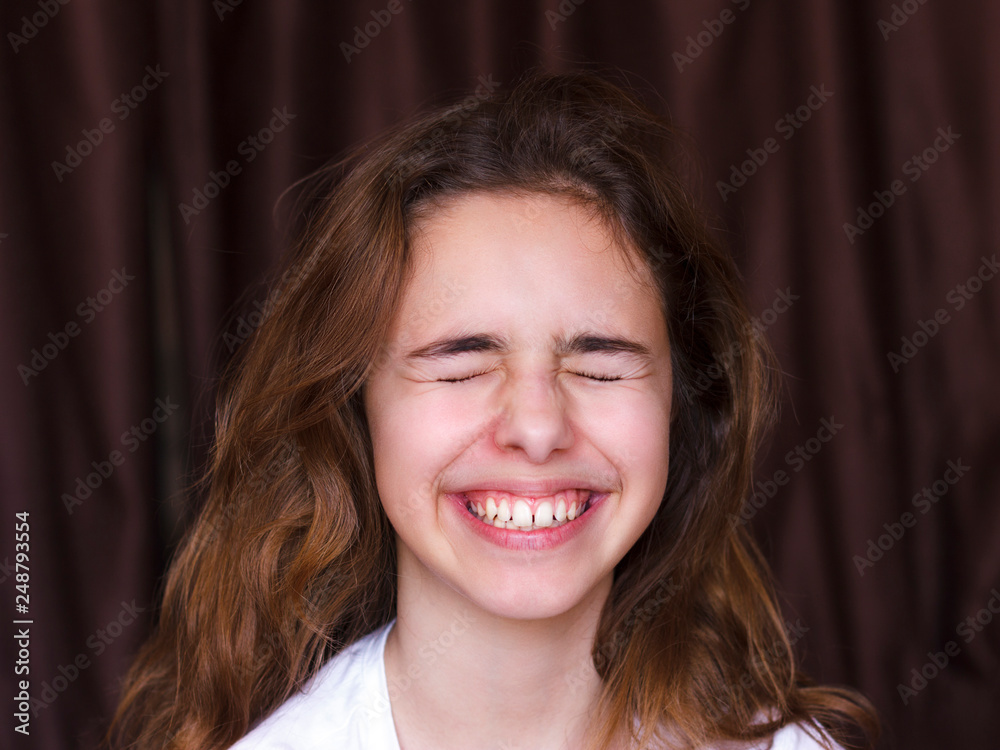 Pretty teenager girl with long hair makes very funny face and laughing with  closed eyes Stock Photo | Adobe Stock