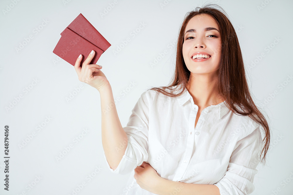 Happy smiling asian young long hair woman with two passports on white background isolated Happy smiling asian young long hair woman with two passports on white background isolated