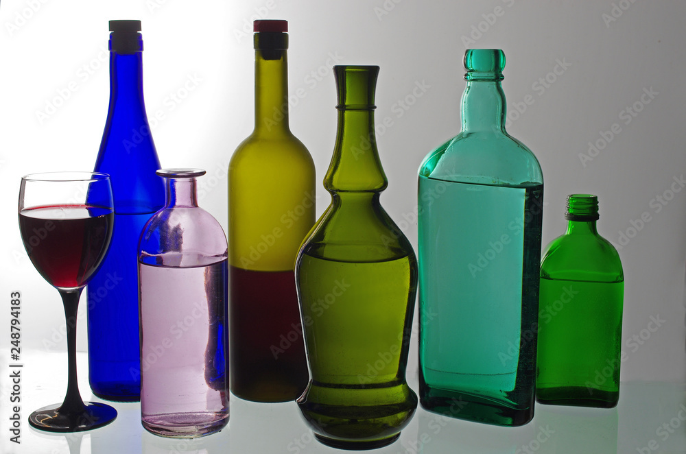 Bottles with wine, liqueurs and spirits on a white background.