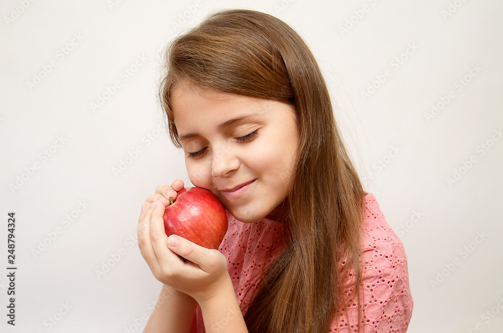 girl on a light background with a red Apple in her hands girl on a light background with a red Apple in her hands