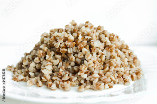 Buckwheat. Boiled buckwheat grains on a white plate. Concept food background.
