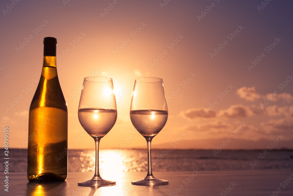 two glasses of wine on a beach sunset background 