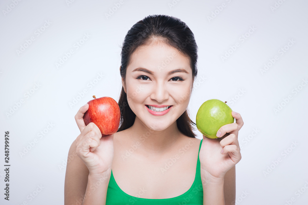 Attractive smiling young asian woman holding green apple isolated over white background. Attractive smiling young asian woman holding green apple isolated over white background.