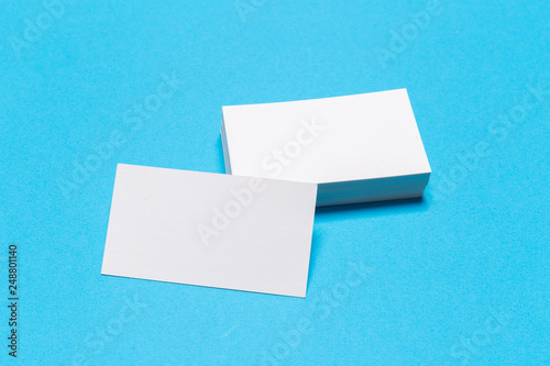 Blank white business cards on blue background. Mockup for branding identity. © Nana_studio