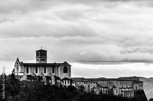 Beautiful view of St.Francis church in Assisi town (Umbria, Italy) from an unusual place, with moody clouds in the sky