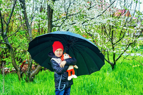 Portrait of a little boy with an umbrella on a spring walk