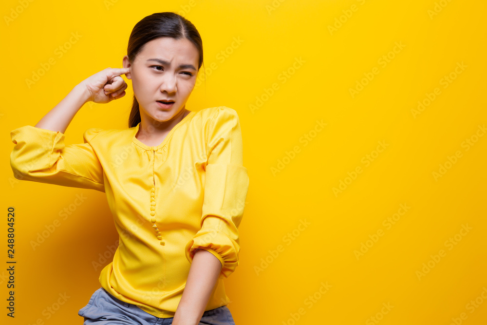 Woman putting a finger into her ear Woman putting a finger into her ear