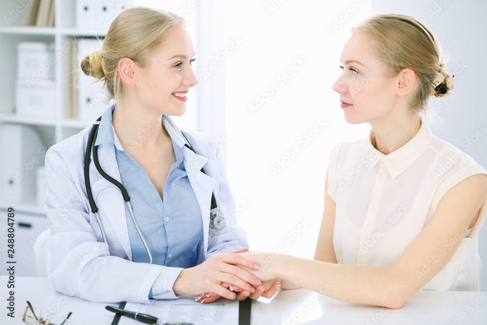 Doctor and patient talking in hospital office while sitting at the desk. Health care and client service in medicine Doctor and patient talking in hospital office while sitting at the desk. Health care and client service in medicine