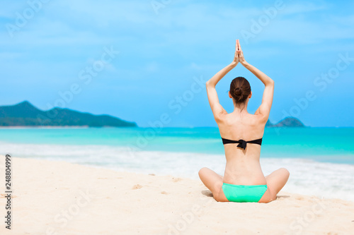 young woman doing yoga on the beach © kieferpix