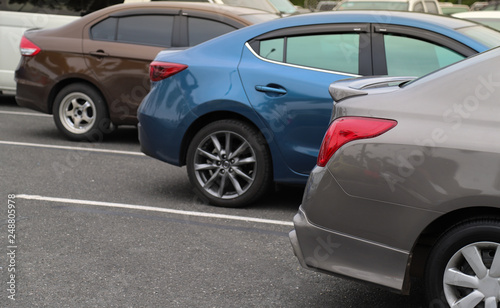 Closeup of back or rear side of brown car and other cars parking in parking area.