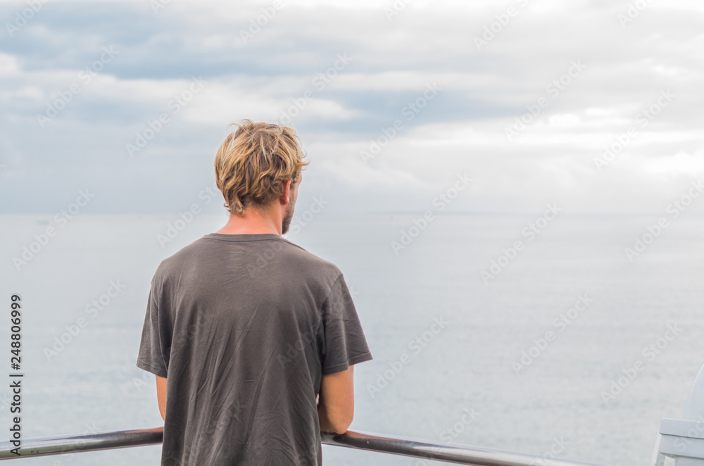 Anonymous man on a ferry boat. Surfer traveling by sea around the Indian ocean.Peaceful time during summer vacation.