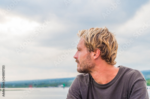 Thoughtful man on a ferry boat during a sea voyage. Freedom and peace.