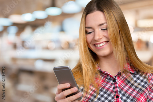 Cheerful young woman holding mobile phone