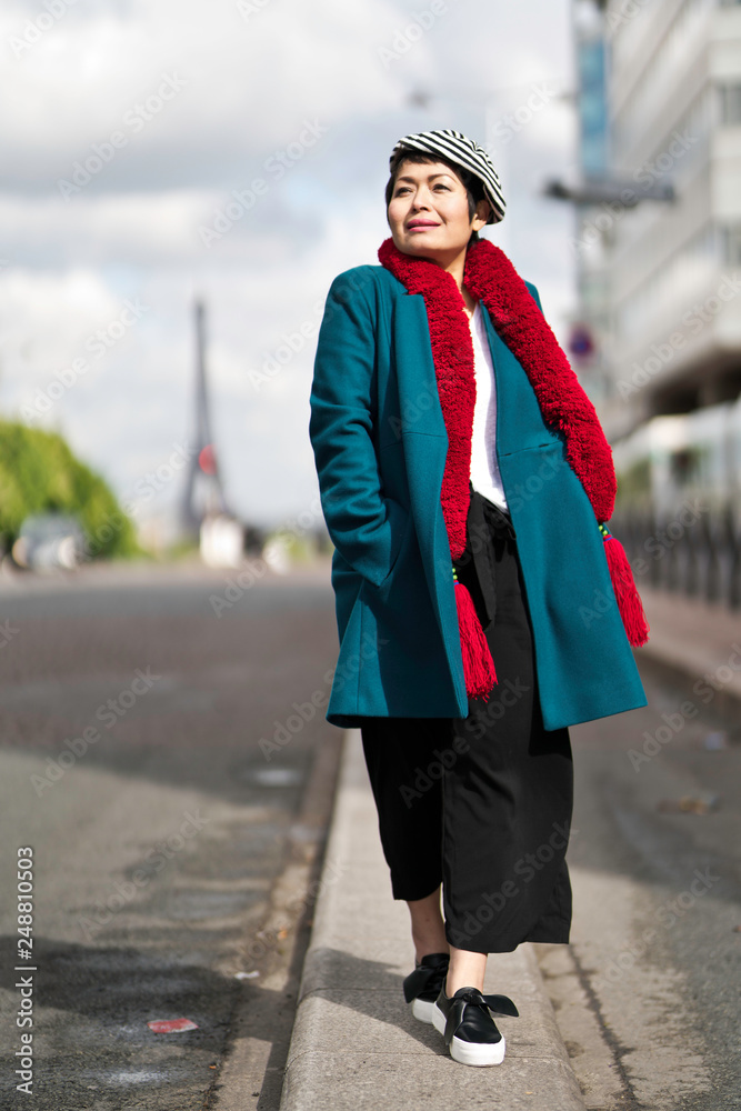 Obraz premium Femme marchant dans la rue avec tour eiffel en arrière plan