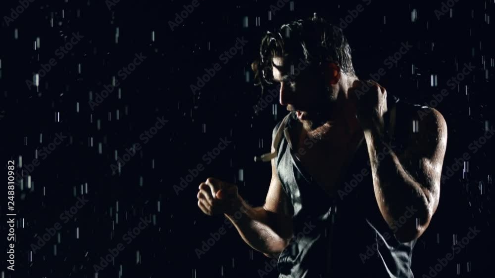 Athletic man shadow boxing in the rain. Athletic man shadow boxing in the rain.