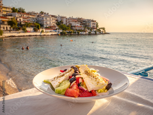 Fototapeta Naklejka Na Ścianę i Meble -  Greek Salad in sunset light at a tavern in Skala Marion town, Thasos Island, Greece
