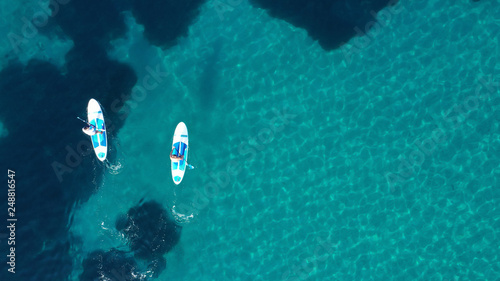 Photography Aerial drone bird's eye view of 2 men exercising sup board in turquoise tropical