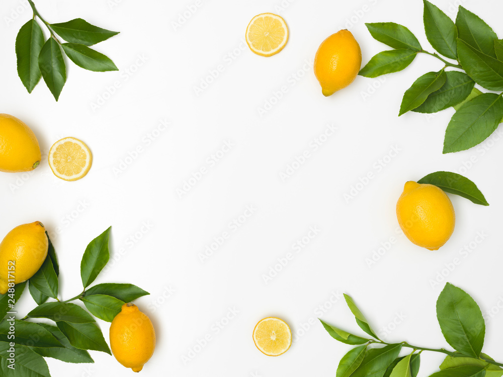 fresh, juicy, yellow lemons with green twigs lie on a white background