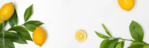 fresh, juicy, yellow lemons with green twigs lie on a white background