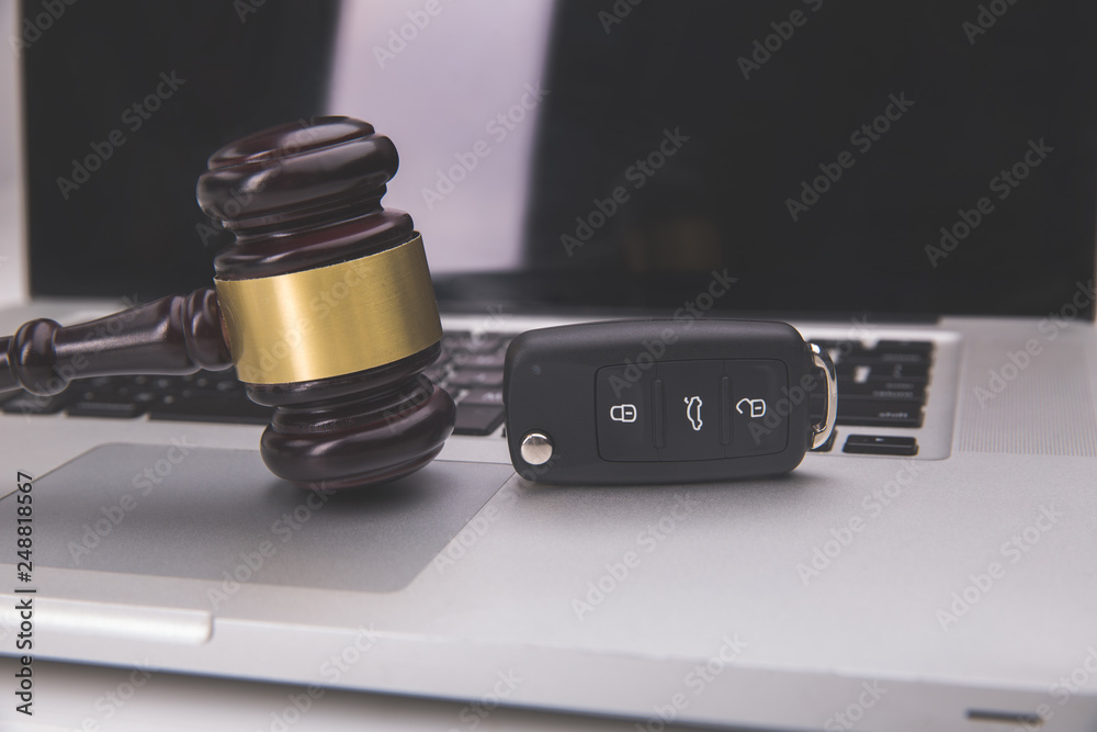 Judge gavel and car key on laptop keyboard. Symbol of law, justice and online auction