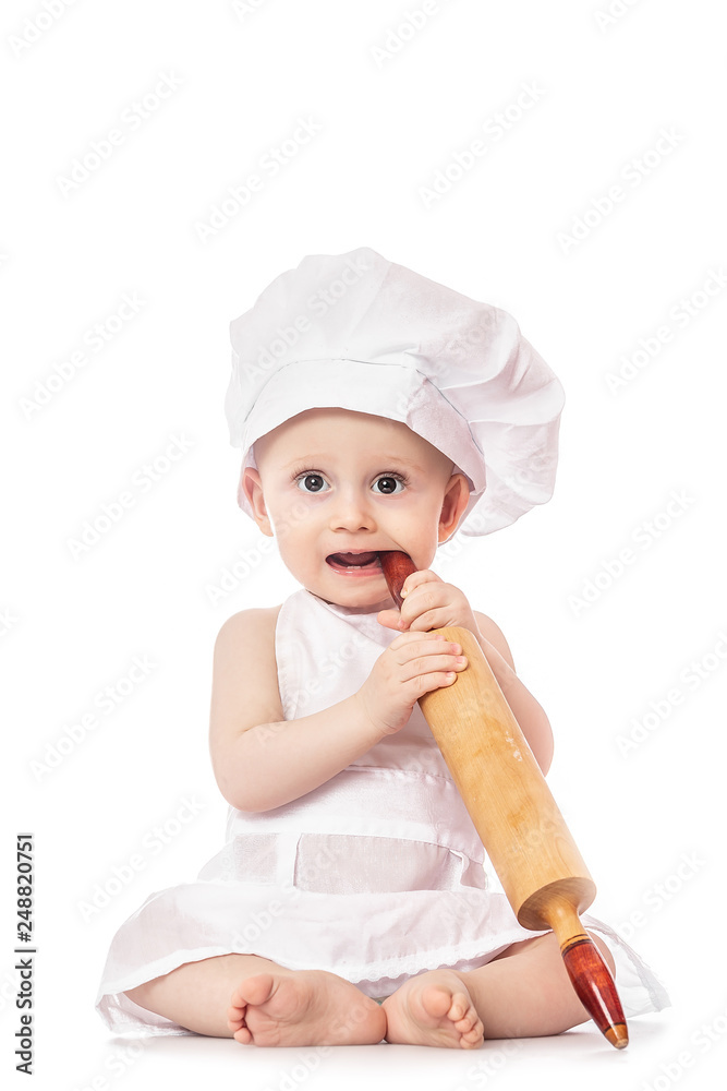 Baby wearing a chef hat with dough rolling pin, isolated on a white background. healthy food concept Baby wearing a chef hat with dough rolling pin, isolated on a white background. healthy food concept