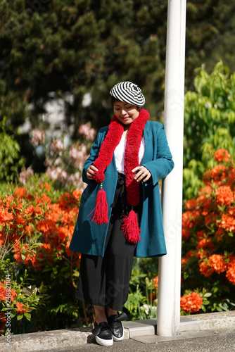 Femme beret et écharpe rouge jardin et massif d'hibiscus