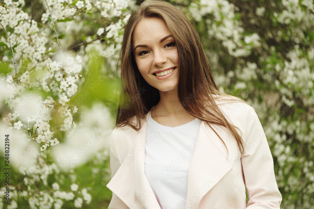 Beautiful brunette girl posing for photo with flowers