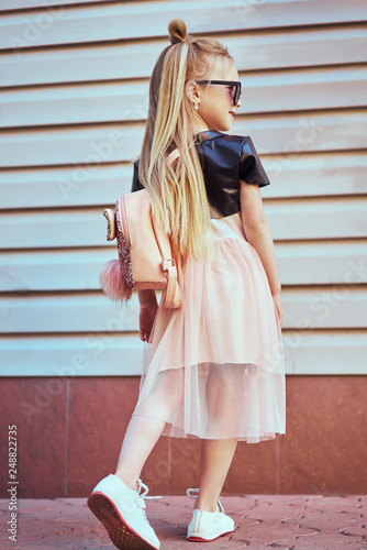 Adorable toddler girl wearing pink dress. Fashion portrait