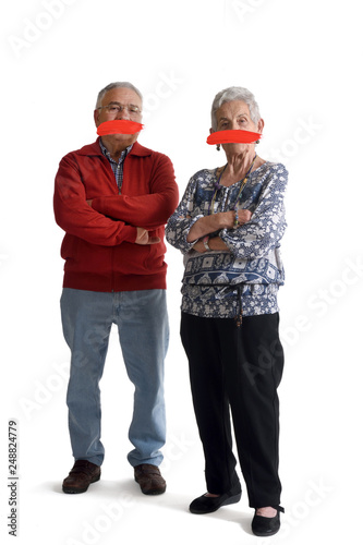 senior couple with mouth covered on white
