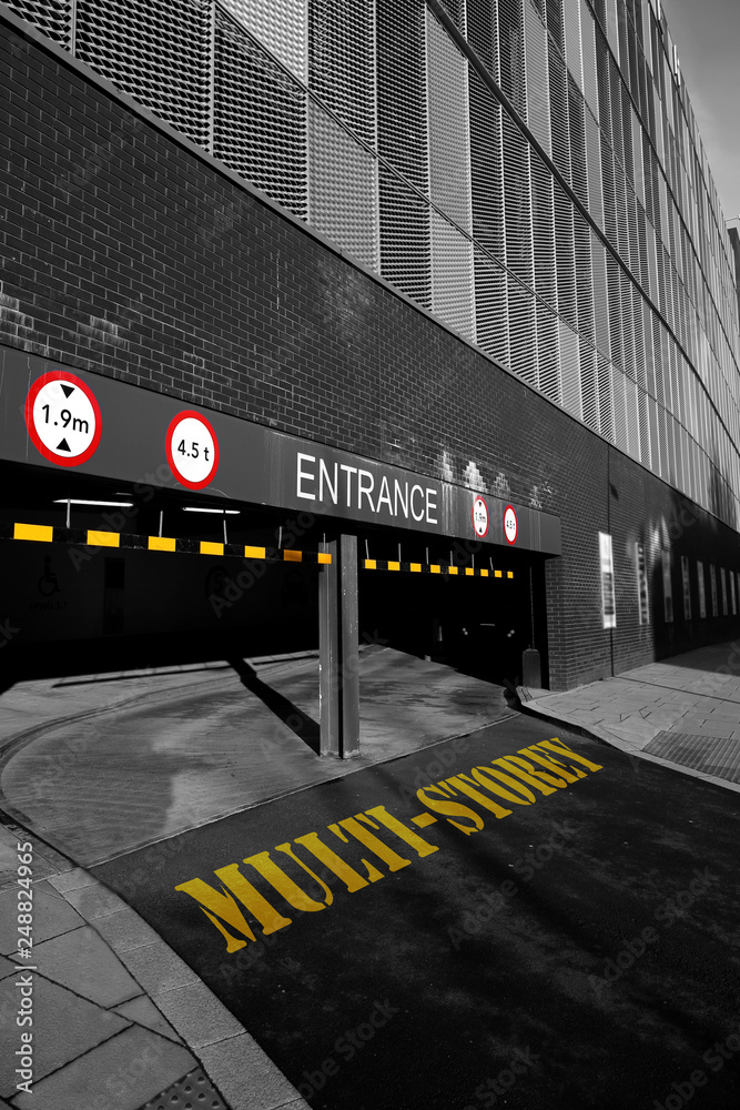 The words multi-storey written on the entrance to a multi-storey car park with warning signs with selective colour