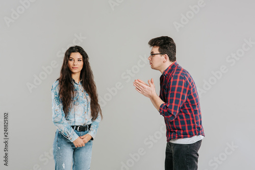 Fototapeta the husband asks for forgiveness from his wife, familiar problems, isolated on the gray background