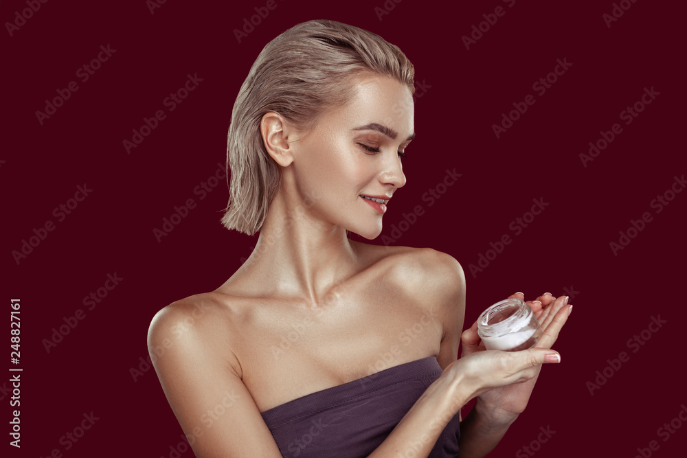 Slim model with natural makeup promoting cream while posing Slim model with natural makeup promoting cream while posing